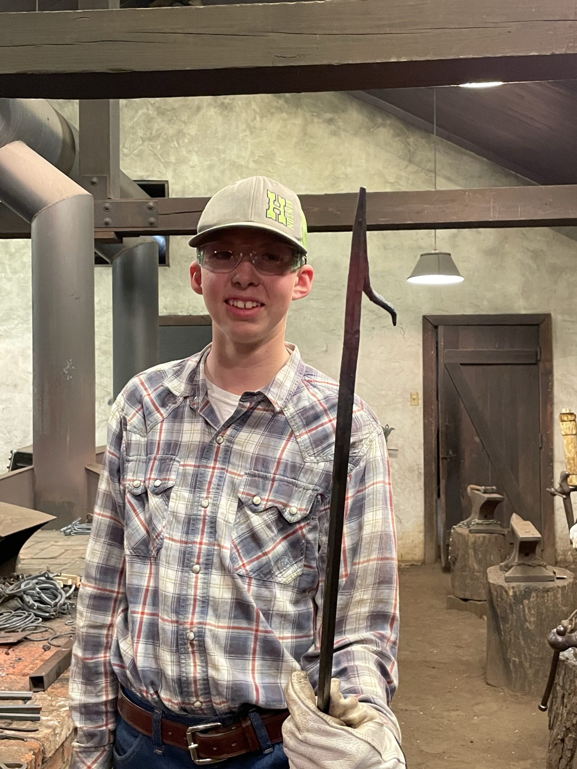 Student hold up wroght iron fireplace poker being prepared for the Homestead Fair